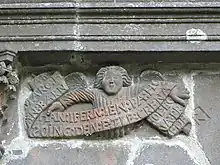 Inscription en breton au-dessus de la porte de l'ossuaire de La Martyre.