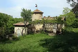 Vue d'une bastide près des berges du Lez avec sa girouette évoquant Mercure, dieu du commerce.