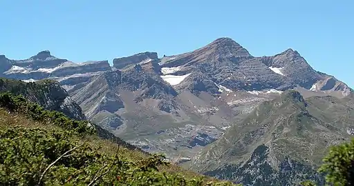 De gauche (à l'est) à droite (à l'ouest), le casque du Marboré (3 006 m) avec sa forme caractéristique, ensuite la brèche de Roland (2 807 m) qui vient interrompre une pente régulière de la ligne de crête, montant légèrement d'est en ouest, vers la pointe Bazillac (2 975 m). Puis on trouve une autre brèche, dite la Fausse Brèche (2 909 m en son point le plus bas), à l'intérieur de laquelle se trouve le « doigt de la Fausse Brèche » (2 944 m), que l'on entrevoit à peine à cette distance. Ensuite, l'imposant pic du Taillon (3 144 m) et enfin les pics des Gabiétous (3 044 m et 3 031 m) .