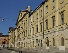 Photographie de la façade d'un bâtiment de couleur ocre.