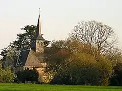 Vue d'ensemble d'une chapelle légèrement masquée par des arbres.