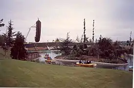 Photographie de deux attractions : une rivière avec des petites barques, et un bateau pirate géant se balançant.