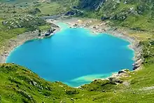 Une étendue d'eau turquoise dans une cuve naturelle vue de dessus.