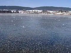 Vue de la commune avec le lac gelé en premier plan.