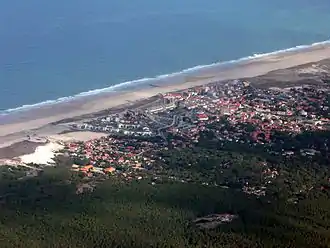 Côte d'Argent, vue aérienne du littoral dans le Médoc. On distingue tour à tour : la forêt des Landes, la station balnéaire de Lacanau, le cordon dunaire, la plage, l'océan.