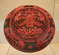 Boîte laquée rouge datant du règne de l’empereur Qianlong (1735-1796) de la dynastie Qing. L’idéogramme inscrit sur le dessus signifie « printemps ».