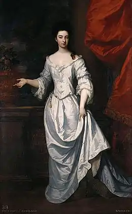 Portrait en pied d'une élégante jeune femme brune, en longue robe blanche