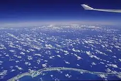 Image aérienne du lagon Bleu (en bas à gauche) avec au loin l'atoll de Tikehau.