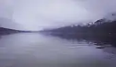 Vue d'un lac avec du brouillard en arrière-plan.