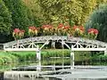 Un petit pont de bois au-dessus du canal à Lalinde.