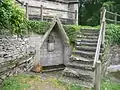 Chapelle Notre-Dame de Lambader : la fontaine du mur sud de la chapelle et sa pietà.