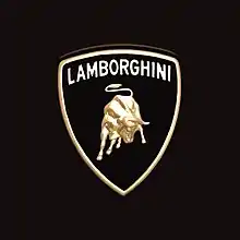 photo couleur d'un blason orné d'un taureau musclé à tête baissée, d'allure agressive, surmonté du nom de la marque : « Lamborghini ».