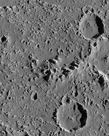 Vue de la surface, montrant de nombreux petits pics et deux larges cratères.