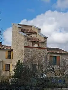 Aux Granges de Vigneras, pigeonnier en forme de tour carrée séparant en deux l'habitation.