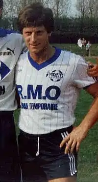 Jean-Michel Larqué posant lors d'une photo d'équipe. On voit le bras d'un coéquipier sur sa droite.