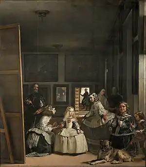 Scène d'intérieur. Un peintre peint. Un groupe de personnes est au centre au premier plan dans la pièce, un chien est couché. Un homme et une femme se reflètent dans un miroir en fond