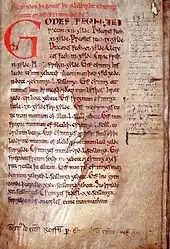 Page d'un manuscrit médiéval, le texte est rédigé à l'encre noire avec une grande lettrine rouge.