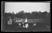 Photo noir et blanc d'un match de lawn tennis dans un parc.