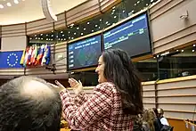 Leïla Chaibi en hémicycle, applaudissant l'issue du vote favorable aux travailleurs de plateforme du 2 février 2023.