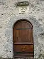 Porte de l'église avec le blason de la  famille Hélie de Colonges.