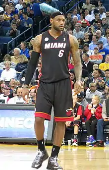 LeBron James sous le maillot noir du Heat, avec le ballon à la main.