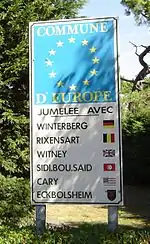 Photo du panneau à l'entrée de la commune indiquant la liste des villes jumelées
