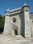 Vue de la façade : le chemin de ronde encadré par deux échauguettes et l'oculus excenté.