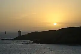 Silhouette de la presqu'île et du phare de Kermorvan lors d'un coucher de soleil.