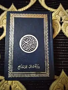 le Coran, couverture bleue inscription et décoration en argent sur un tapis