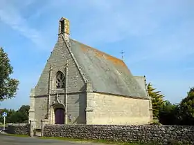 Vue d’une chapelle aux murs de granit et toit en ardoises.