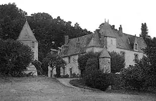 Photographie en noir et blanc d'un château du hameau qui l'entoure.