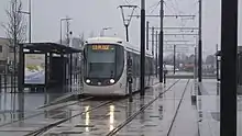 tramway à la station Grand Hameau, sous la pluie.