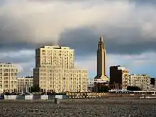 Vue de l'église et d'immeuble d'habitations situé en bord de mer, photo prise depuis la plage visible au premier plan.