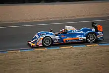 Photo d'une voiture de course sur un circuit.