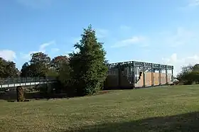 Le musée Argentomagus en 2009 ; bâtiment en brique rouge et verre au milieu d'un parc, rejoint par une passerelle de métal venant de la gauche.