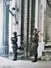 deux soldats allemands casqués, fusil sur l'épaule, se tiennent dos à la façade du château de Laeken