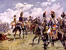 Napoléon à gauche de l'image, avec derrière lui et en train de lui parler un officier à cheval de dos, coiffé d'un bonnet à poils noirs et vêtu d'une veste bleue, avec au centre et à droite des cavaliers habillés de même.