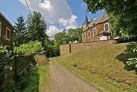 Photographie d'un village, au milieu une route, à droite une église.