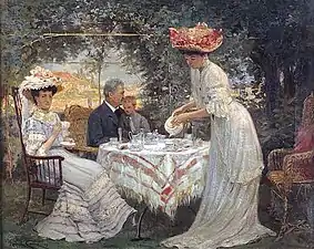 Une femme servant du thé à une autre femme, un homme et un enfant.