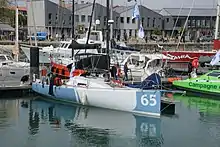 Le monocoque aux côtés d'autres voiliers de la flotte dans le port de La Rochelle