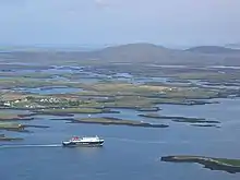 Vue aérienne d'une partie de North Uist avec un ferry quittant Lochmaddy.