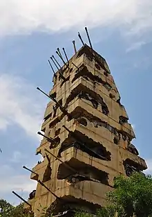 Une monumentale tour de béton englobant de canons pointés vers le ciel