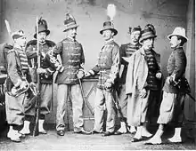 Photographie en noir et blanc de sept soldats en uniformes.