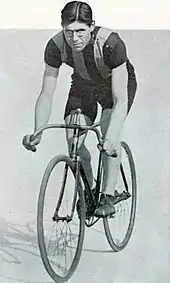 Photo d'un homme de trois quarts face sur son vélo.