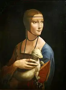 Image montrant un portrait de trois-quart, le visage tourné vers le spectateur et faisant un geste de la main. Elle porte une robe somptueuse et un collier de perles, la tête enveloppée d’un précieux voile transparent.