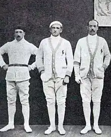 Photo de trois hommes prenant la pose côte-à-côte dans leurs tenues d'escrimeurs