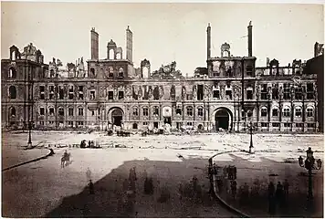 Façade grise d'un grand bâtiment sans toit ni fenêtre.