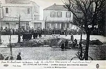Carte postale en noir et blanc montrant un cratère au milieu d'un boulevard, provoqué en 1916 par une bombe