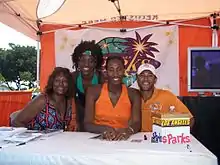 Lisa Leslie avec deux autres personnes, une troisième debout derrière elle.