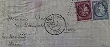 Photographie en couleur d'une lettre, deux timbres sont apposés, un rouge, l'autre bleu.
